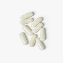 Magnesium Glycinate capsules scattered on a white background, supporting relaxation, sleep, and heart health.
